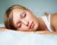Beautiful young female sleeping on bed