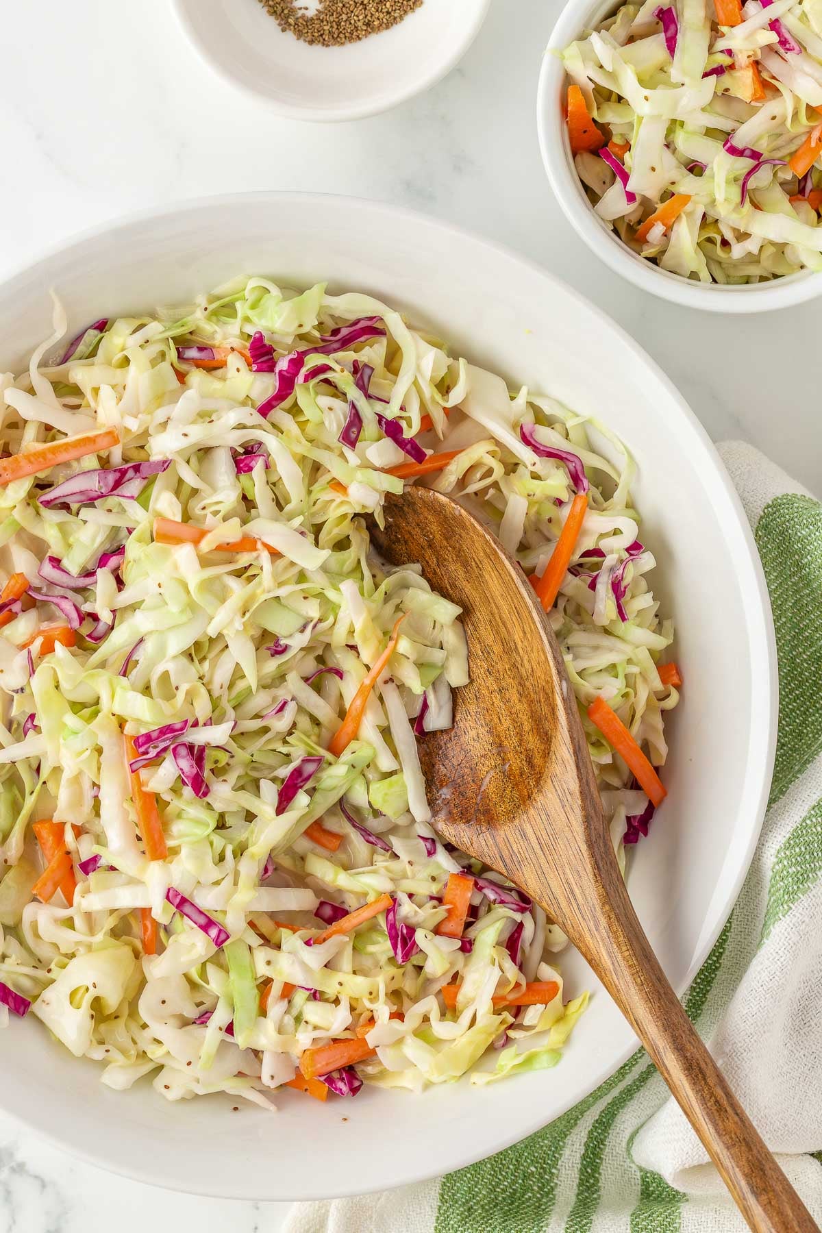 close up of creamy sweet coleslaw recipe dressing coating shredded cabbage