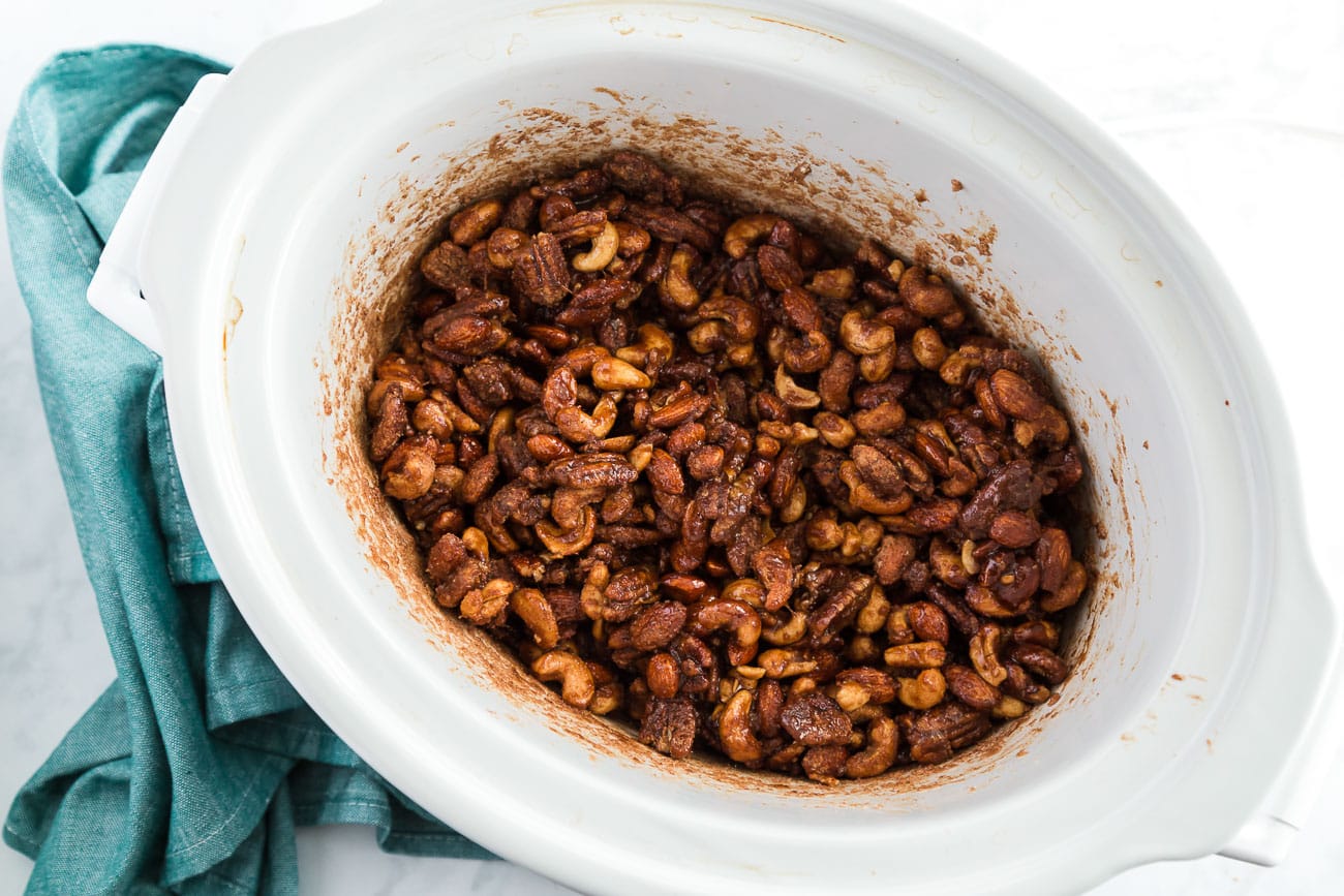 mixed nuts coated in cinnamon sugar inside a slow cooker