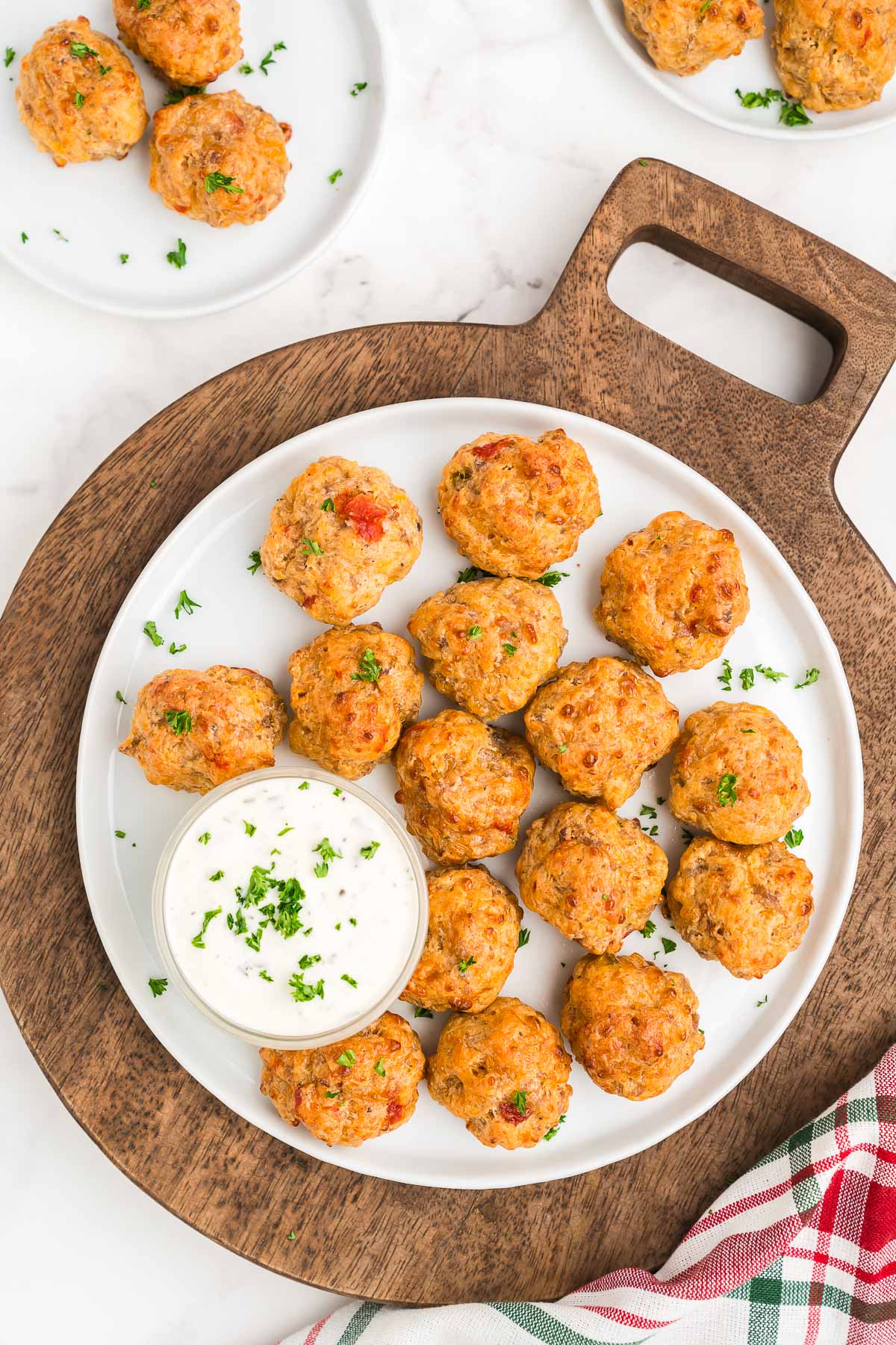 warm appetizer balls piled on a serving plate with a sprinkle of parsley