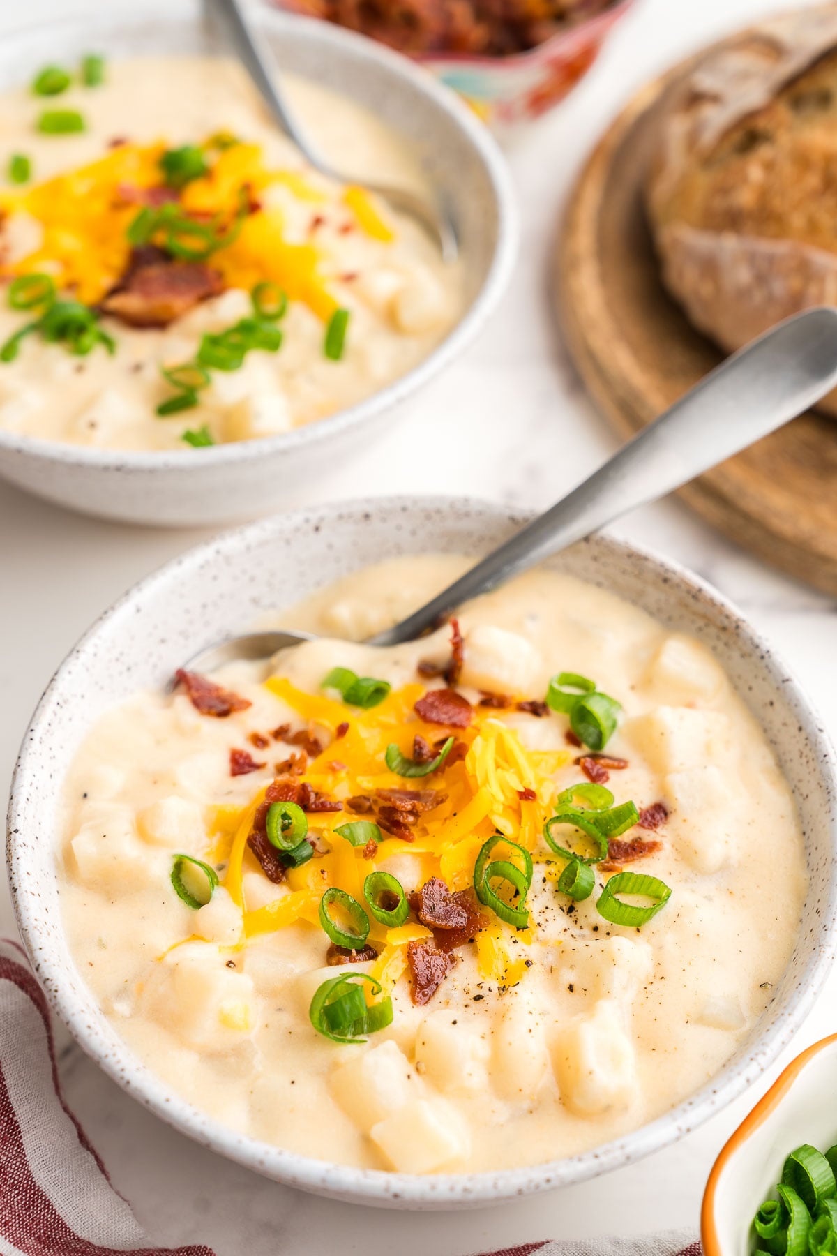 A creamy bowlful topped with cheddar, bacon and sliced green onions