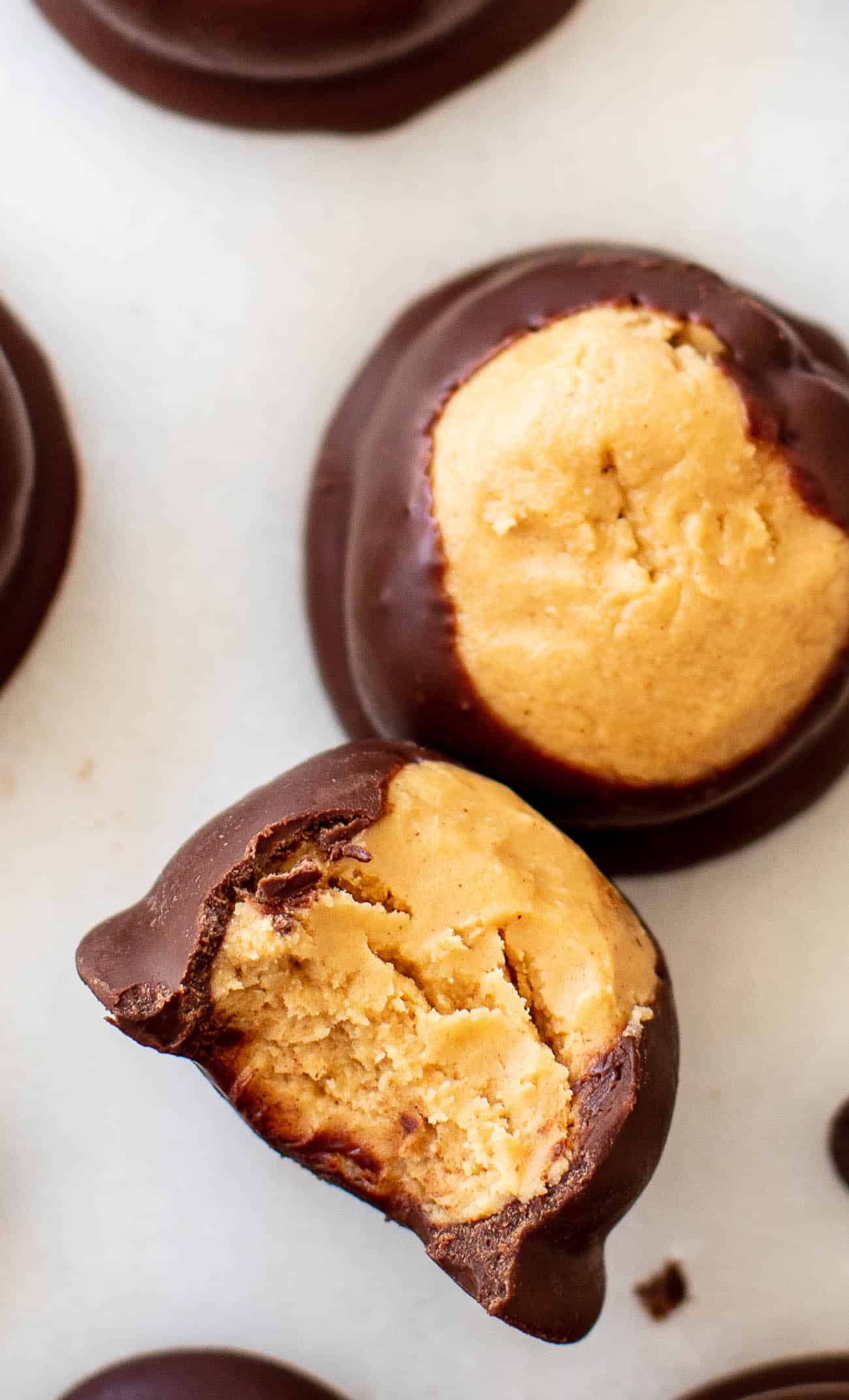 A buckeye ball with a bite taken out, showing the creamy peanut butter center.
