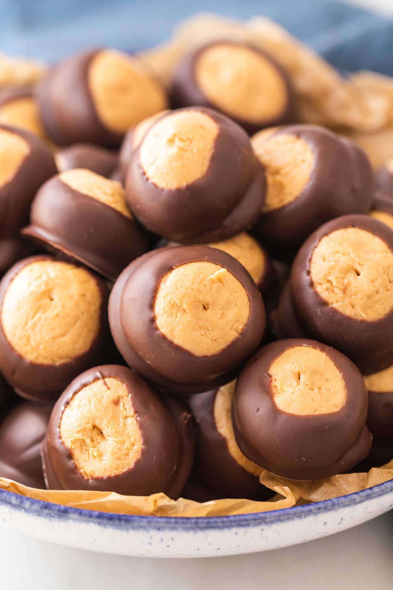 Chocolate peanut butter buckeyes heaped in a blue-rimmed bowl.