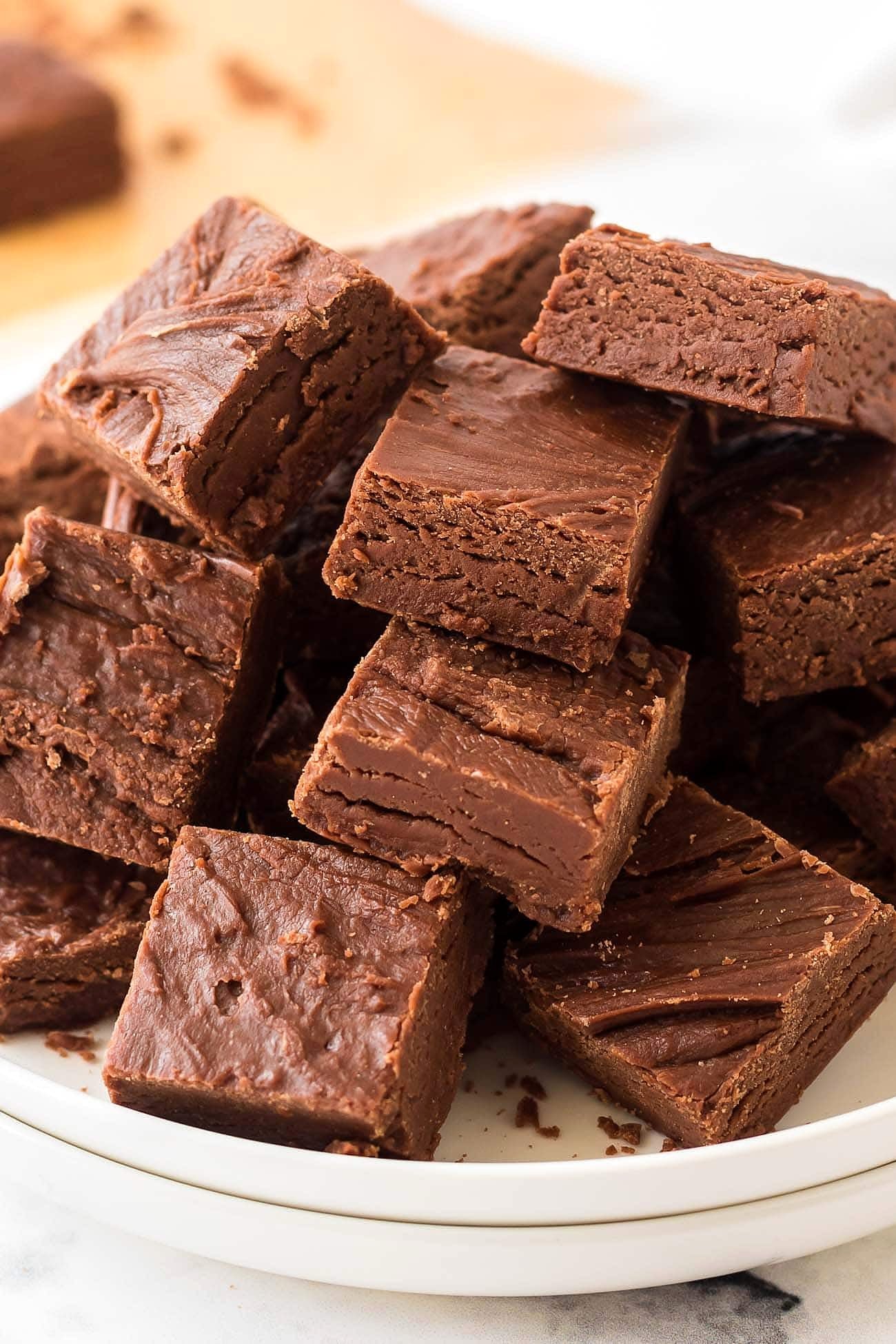 Close-up of creamy chocolate fudge squares stacked on a plate