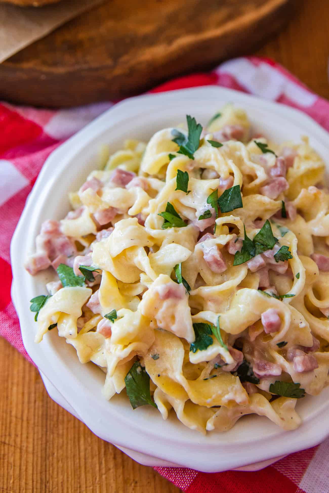 A serving of the creamy pasta bake on a white plate with fresh parsley