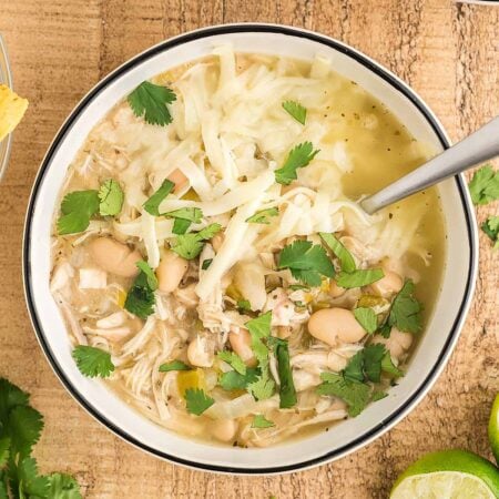 overhead bowl of keto white chicken chili topped with cheese and cilantro