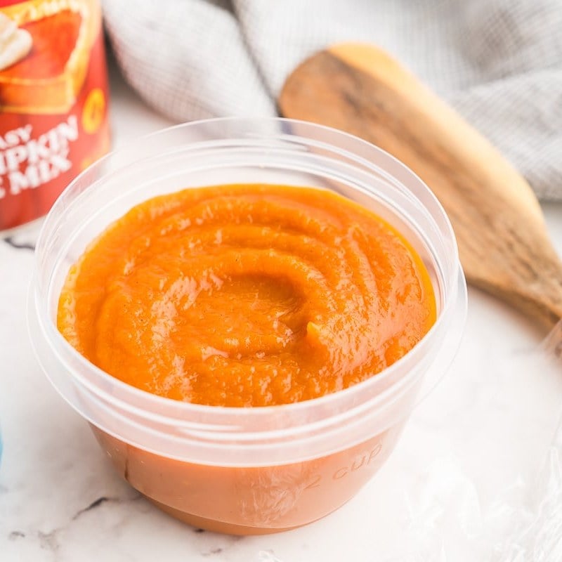 Leftover pumpkin pie filling in a small plastic storage container