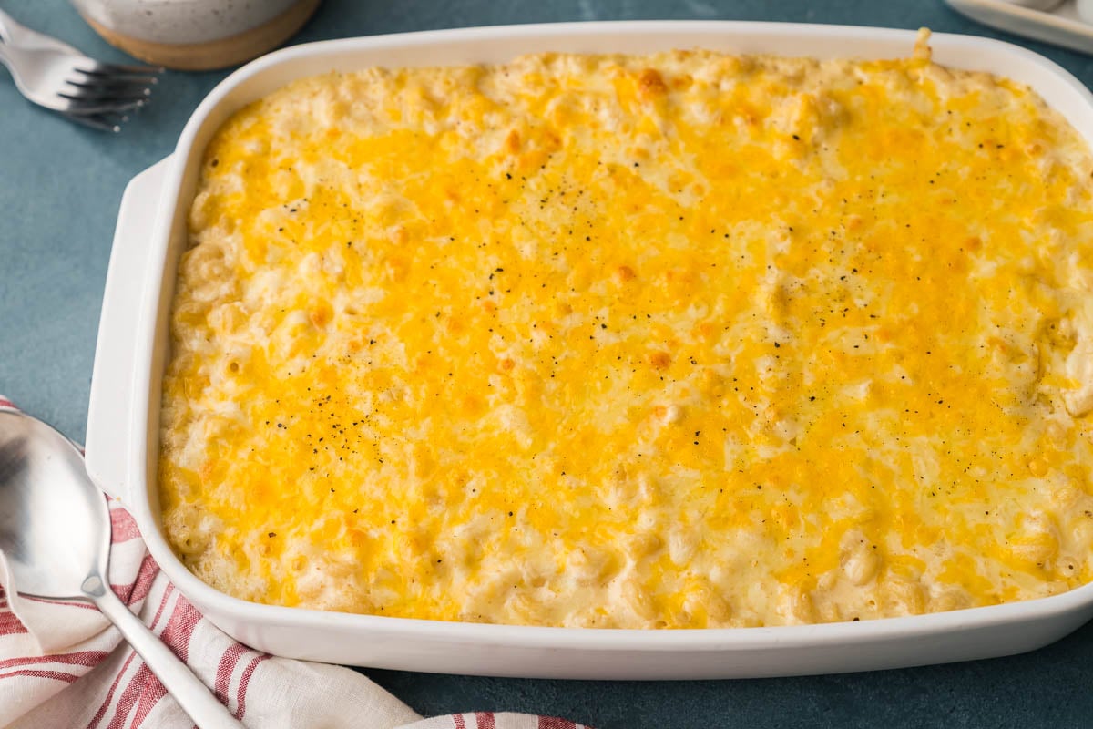 Whole pan of old fashioned baked mac and cheese with a golden, bubbly cheese top and black pepper.