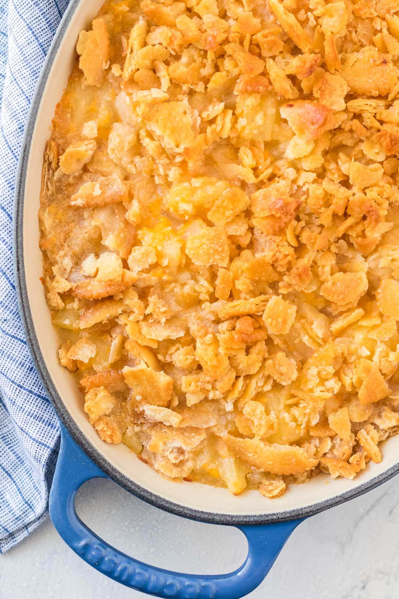 Crispy golden Ritz cracker topping baked in a blue oval dish