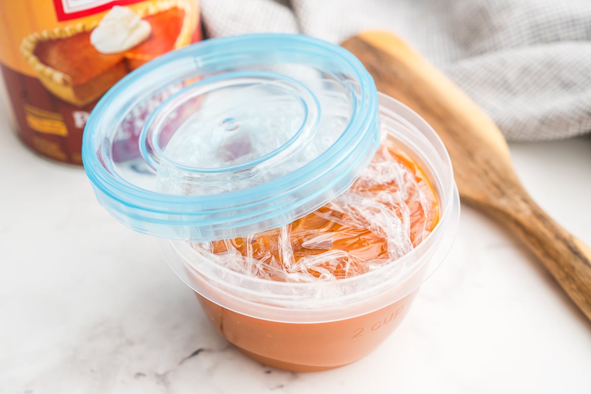 Plastic wrap pressed right onto the surface inside a storage container